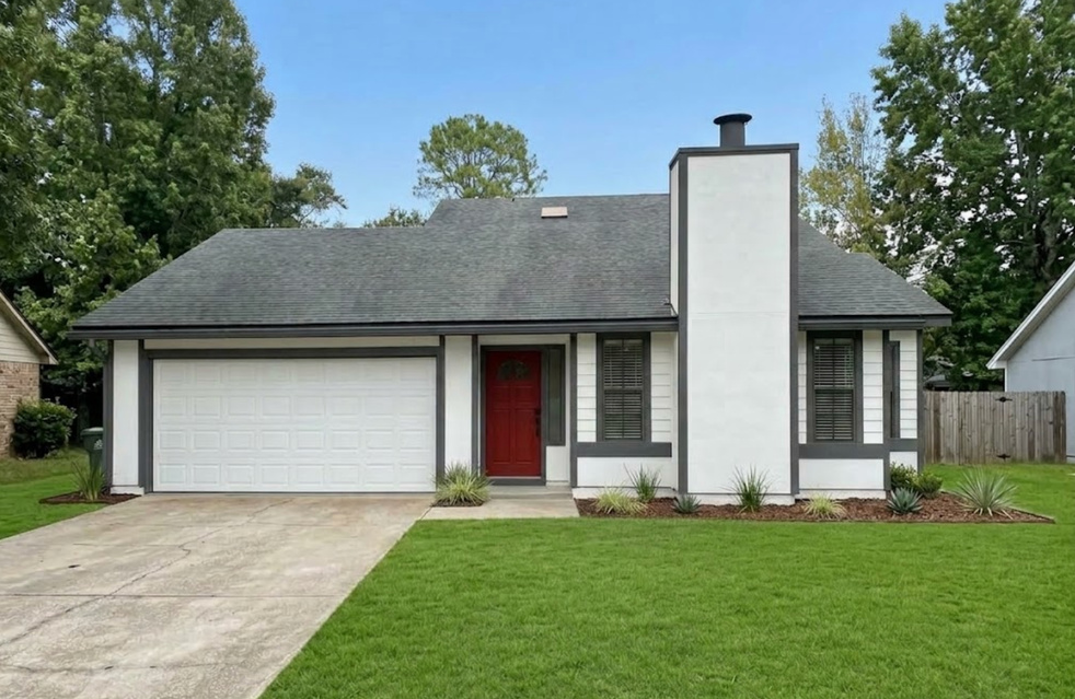 Rendering of a single-family home with white siding and chimney, charcoal trim, a red front door, white garage door and fresh landscaping